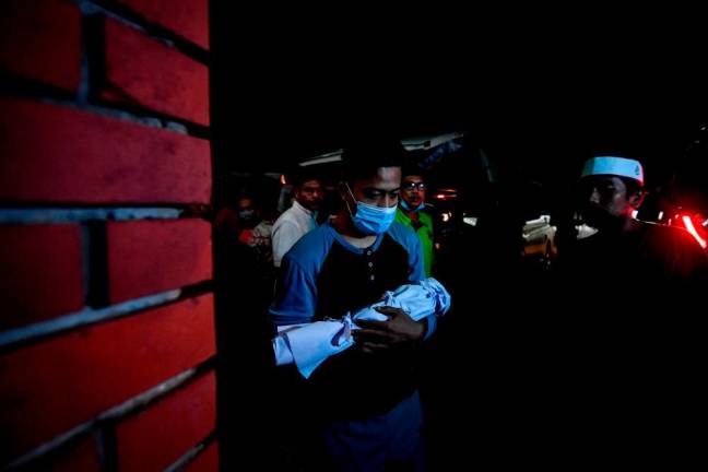 Muhammad Khairul Asyraf Nor Azman, 24, membawa janin Allahyarhamah isterinya berusia hamil empat bulan memasuki Surau Al-Istiqamah untuk disembahyangkan sebelum dikebumikan di Tanah Perkuburan Islam Kampung Charuk Bemban/BERNAMAPix