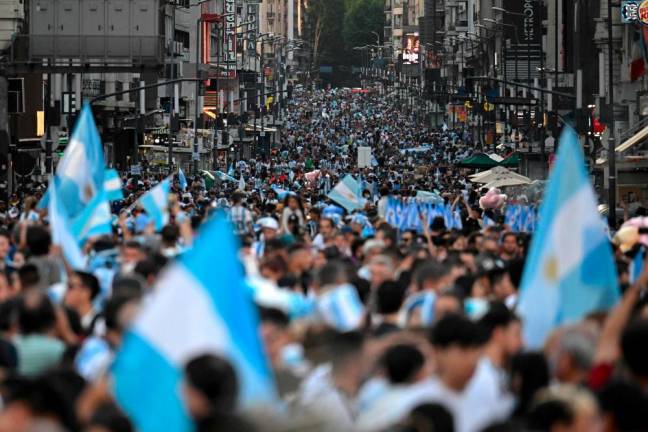 Football fans of Argentina celebrate after Argentina defeated Australia in the Qatar 2022 World Cup round of 16 football match, at 9 de Julio avenue, in Buenos Aires, on December 3, 2022/AFPPix