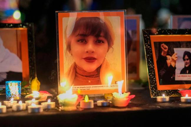 Candles and pictures of Mahsa Amini are placed at a memorial during a candlelight vigil for Mahsa Amini who died in custody of Iran’s morality police, in Los Angeles, California, September 29, 2022/AFPPix