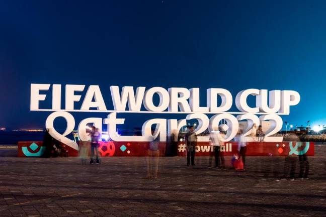 Visitors take photos with a FIFA World Cup sign in Doha ahead of the Qatar 2022 FIFA World Cup football tournament. – AFPPIX