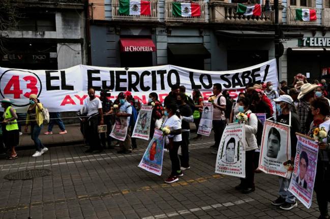 People take part in a march in Mexico City on September 26, 2022, to mark the eighth anniversary of the disappearance of 43 students of the teaching training school in Ayotzinapa. - AFPPIX