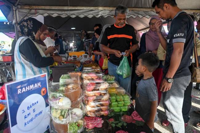 MARANG, 25 Mac -- Orang ramai tidak melepaskan peluang membeli kuih-muih Menu Rahmah yang dijual dengan harga RM5 untuk dua bekas ketika tinjauan di Bazar Ramadan Binjai Rendah. fotoBERNAMA