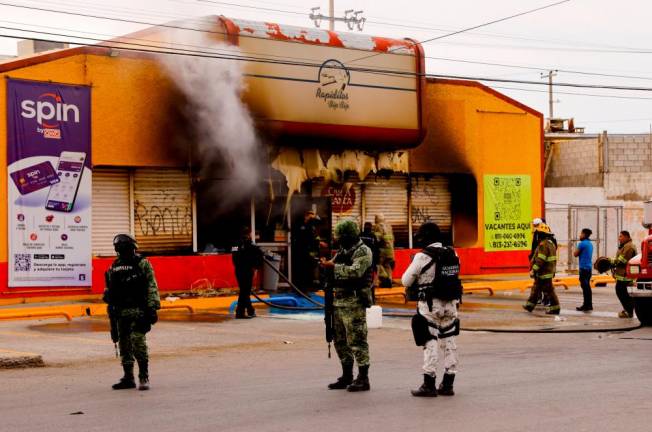 Security forces stand outside a convenience store that was burned by unknown attackers, in a simultaneous attack of fires in different parts of the city, according to local media, in Ciudad Juarez, Mexico/REUTERSPix