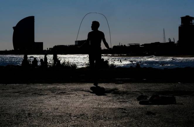 FILE PHOTO: A man skips rope as he exercises at Barceloneta beach, after Spain’s Catalonia region said it would allow gyms to reopen from Monday amidst the coronavirus outbreak, in Barcelona, Spain November 22, 2020. REUTERS/Nacho Doce/File Photo