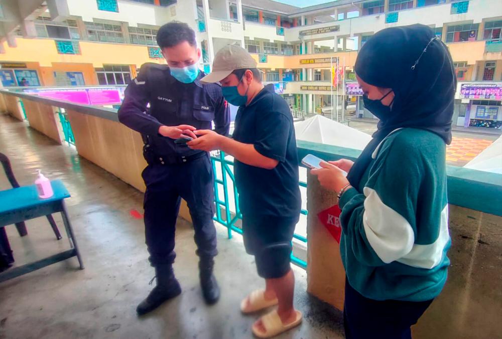Police officers are checking voters’ documents before being allowed to enter Tun Hussein Onn Dua National School in Bandar Tun Hussein Onn, Cheras. Syed Azahar Syed Osman/theSun.
