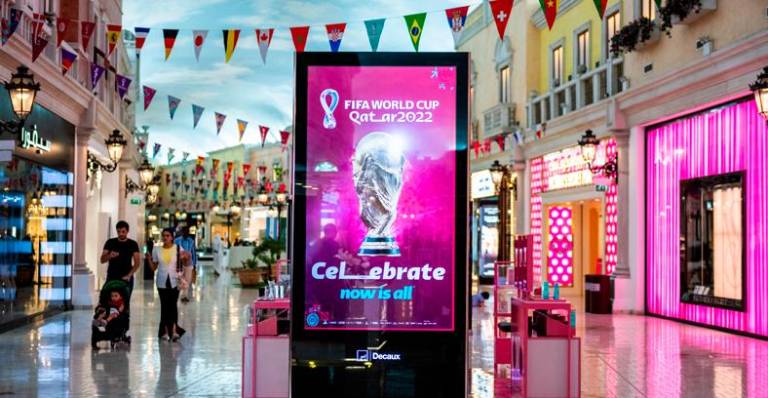 People walk past a screen displaying the FIFA World Cup trophy in a mall in Doha ahead of the Qatar 2022 FIFA World Cup football tournament. – AFPPIX