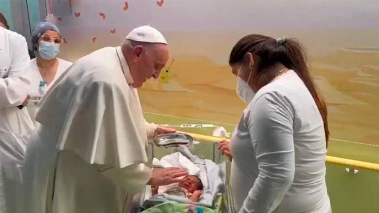 This photo grabbed from a video taken and handout by The Vatican Media on March 31, 2023 shows Pope Francis baptising a baby boy named Miguel Angel, while visiting children at the oncology ward of the Gemelli hospital in Rome, the same hospital where the Pope was admitted to another ward on March 29 for bronchitis/AFPPix