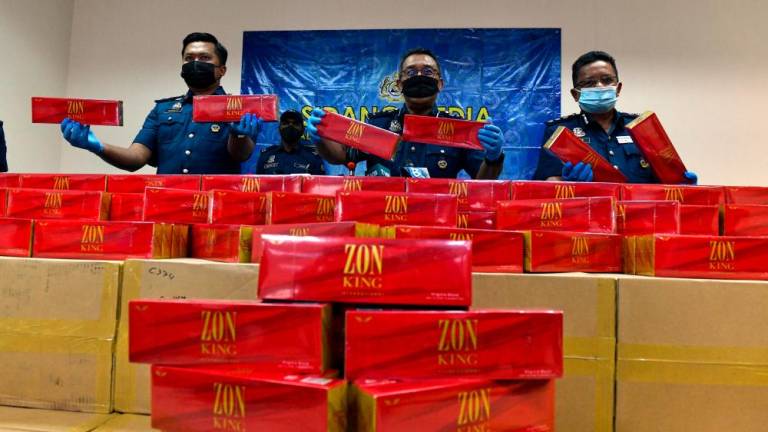 BUTTERWORTH, August 10 — Penang Customs Director, Datuk Abdul Halim Ramli (centre) with his officers showing cartons of smuggled cigarettes seized during a press conference at the Customs Enforcement Store, in Bagan Jermal today. BERNAMAPIX