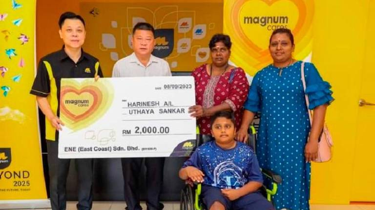 MagnumCares ‘Cepat-Cepat Tolong’ programme, through Magnum East Coast &amp; Selangor vice-president (regional head) Lim See Chin (left), presenting the cash donation to U. Harinesh (on wheelchair), witnessed by Pahang Exco member Sim Chon Siang (2nd from left).