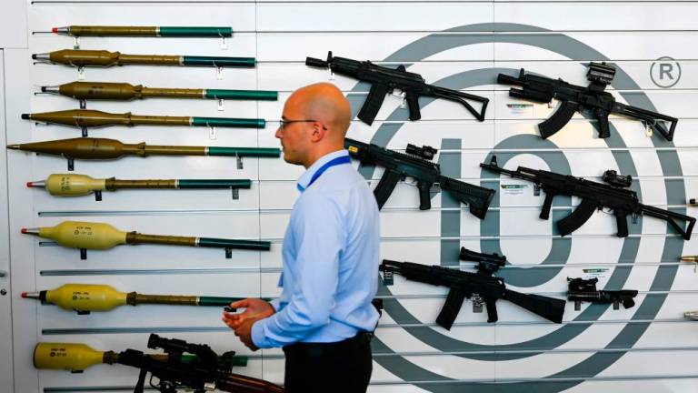 This picture taken on June 1, 2022, shows a man walking past RPG-7, RTB-7MA Thermobaric RPG and rifles at the Arsenal Kazanlak stand, during the 15th Defence Equipment and services Exhibition HEMUS-Defence, Anti-terrorism and Security in Plovdiv, Bulgaria. AFPPIX