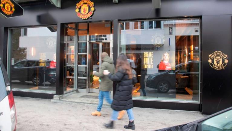 People walk past a lounge of British soccer club Manchester United during the World Economic Forum (WEF) 2023 in the Alpine resort of Davos, Switzerland, January 15, 2023. REUTERSPIX
