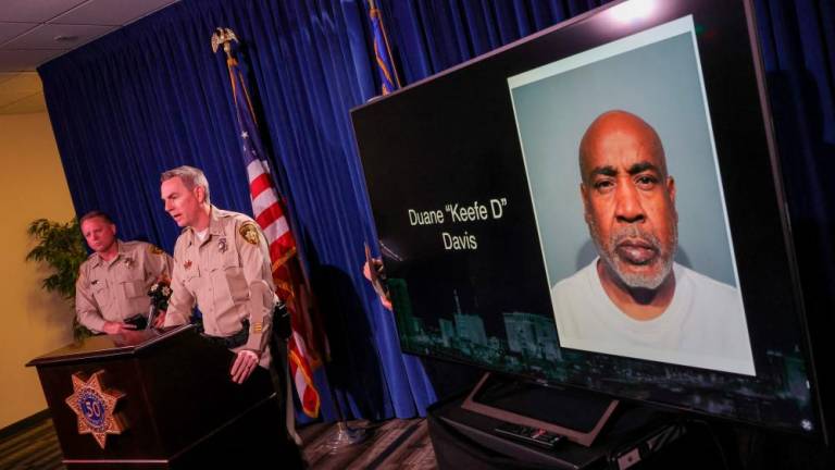LAS VEGAS, NEVADA - SEPTEMBER 29: A booking photo of Duane Keefe D Davis is shown on a television monitor as Clark County Sheriff Kevin McMahill (L) and Las Vegas Metropolitan Police Department Lt. Jason Johansson speak during a news conference at the LVMPD headquarters to brief media members on Davis' arrest and indictment for the 1996 murder of Tupac Shakur on September 29, 2023 in Las Vegas, Nevada. AFPPIX