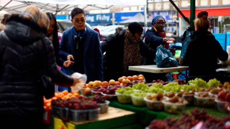 People shop to buy fruit and vegetables at a stall in Lewisham Market, south east London, Britain, March 9, 2023. REUTERSPIX