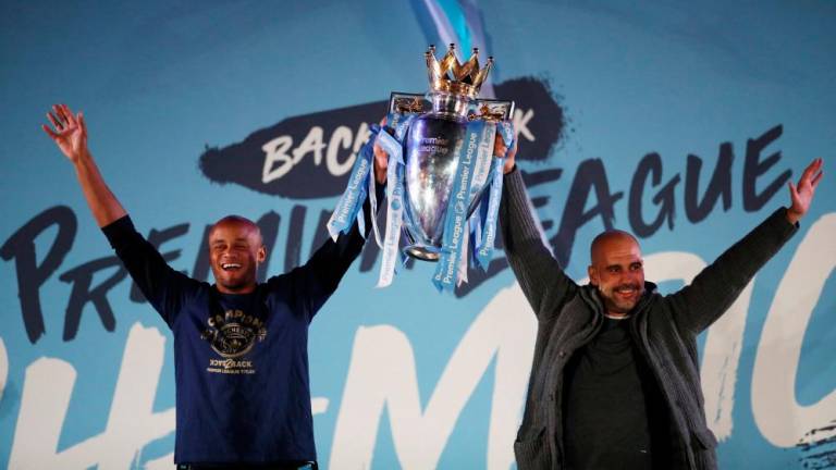 Football - Manchester City Premier League Title Celebrations - Etihad Stadium, Manchester, Britain - May 12, 2019 Manchester City manager Pep Guardiola and Manchester City’s Vincent Kompany celebrate winning the Premier League with the trophy. REUTERSPIX
