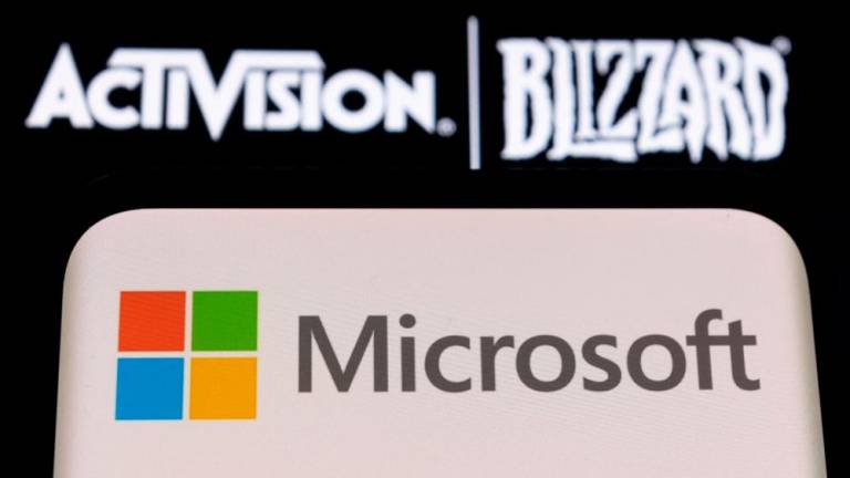 The Microsoft logo is seen on a smartphone placed on displayed Activision Blizzard logo in this illustration. – Reuterspic