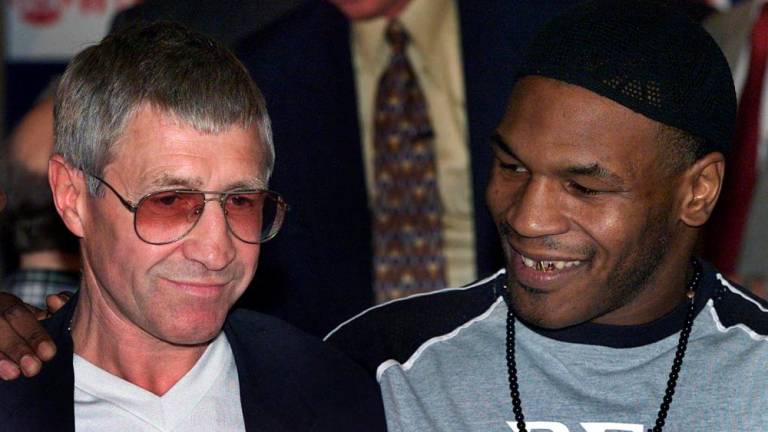 In this file photo taken on June 23, 2000, former world champion boxer Ken Buchanan (L) is embraced by US Mike Tyson (R) before the latter weighed-in at 221 pounds in Glasgow 23 June 2000 for his bout with compatriot Lou Savarese in Glasgow. Scottish boxing great Ken Buchanan has died at the age of 77/AFPPix