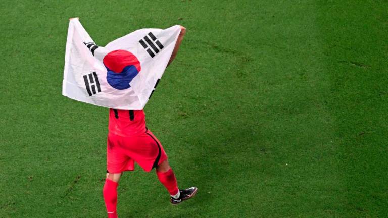 TOPSHOT - South Korea's midfielder #11 Hwang Hee-chan celebrates at the end of the Qatar 2022 World Cup Group H football match between South Korea and Portugal at the Education City Stadium in Al-Rayyan, west of Doha on December 2, 2022. - AFPPIX