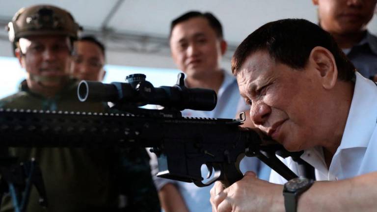 President Rodrigo Duterte (right) firing a few rounds with a sniper rifle during the opening ceremony of the National Special Weapons and Tactics (SWAT) Challenge on March 1st 2018. – AFPPIX