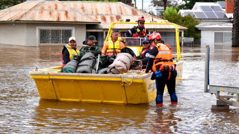 State Emergency Service (SES) personnel navigate floodwaters with residents and supplies aboard a watercraft at the town of Forbes, in the Central West region of New South Wales, Australia, November 16, 2022. REUTERSPIX