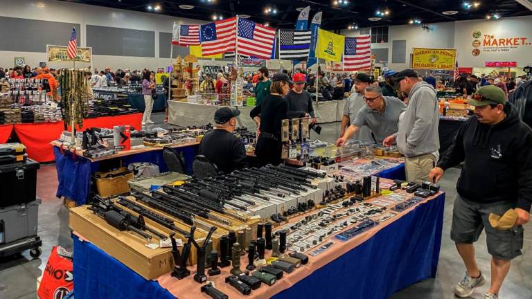 Men browse as vendors sell firearms and accessories at the Crossroads of the West Gun Show at the Convention Center in Ontario, California, on January 28, 2023. AFPPIX