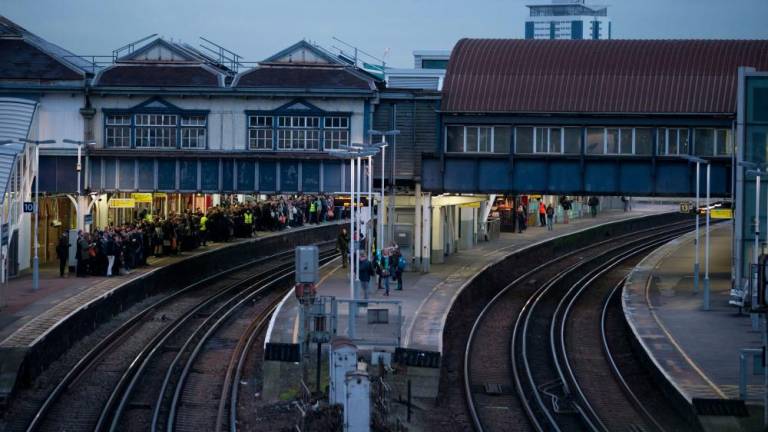 In this file photo taken on January 10, 2017 A platform normally used by Southern Rail (R) is empty of passengers as commuters (L) wait for a train on a platform run by another operator at Clapham Junction station in London during strike action by Southern Rail. AFPpix