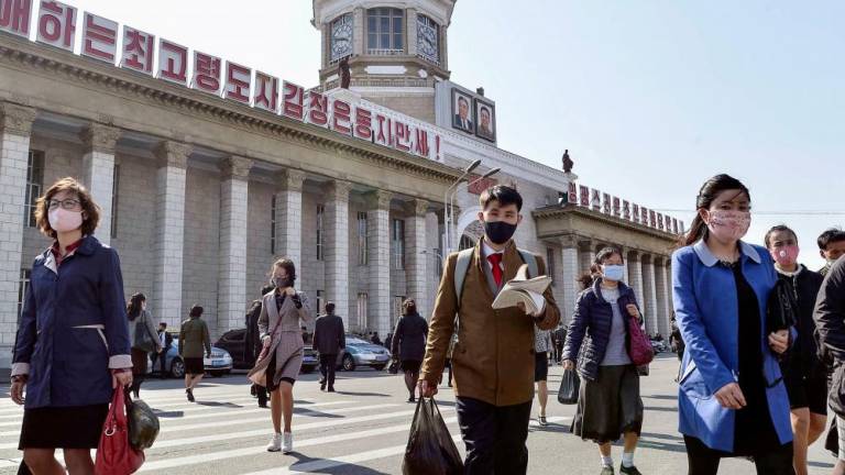 File photo: People wearing protective face masks walk amid concerns over the new coronavirus disease (Covid-19) in front of Pyongyang Station in Pyongyang, North Korea April 27, 2020, in this photo released by Kyodo. Mandatory credit Kyodo/via REUTERSpix