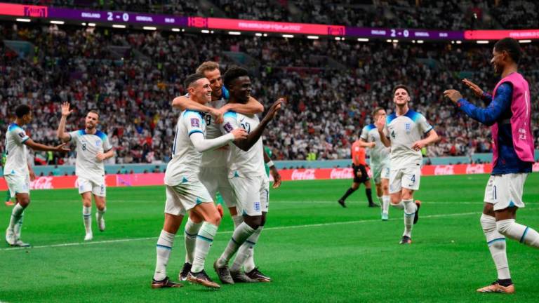England's Bukayo Saka celebrates with Phil Foden (L) and Harry Kane after scoring his team's third goal during the Qatar 2022 World Cup round of 16 football match between England and Senegal at the Al-Bayt Stadium in Al Khor on December 4, 2022. AFPPIX
