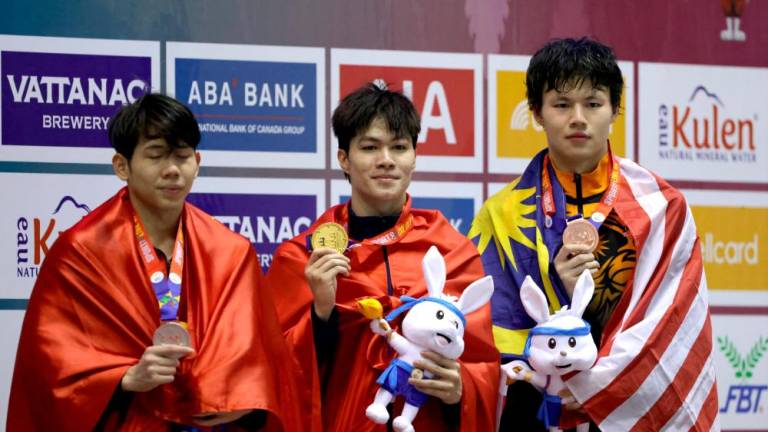 Vietnam’s Hung Nguyen Tran celebrates winning gold medal alongside silver medalist Vietnam’s Quang Thuan Nguyen and bronze medalist Malaysia’s Tan Khai Xin in men’s individual medley 400m/REUTERSPix