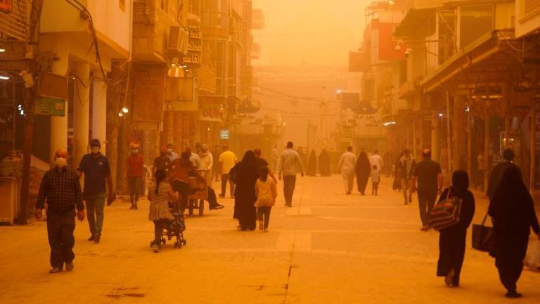 People walk down al-Rasoul street leading to the Imam Ali shrine during a sandstorm in Iraq’s holy city of Najaf on May 16, 2022. AFPPIX