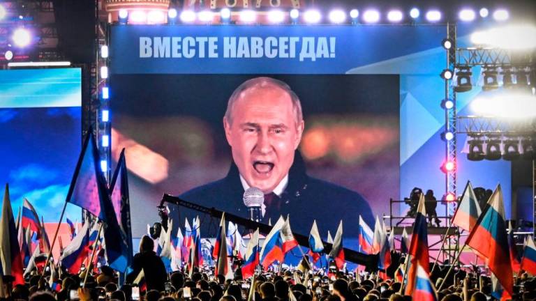 Russian President Vladimir Putin is seen on a screen set at Red Square as he addresses a rally and a concert marking the annexation of four regions of Ukraine Russian troops occupy - Lugansk, Donetsk, Kherson and Zaporizhzhia, in central Moscow on September 30, 2022. AFPPIX