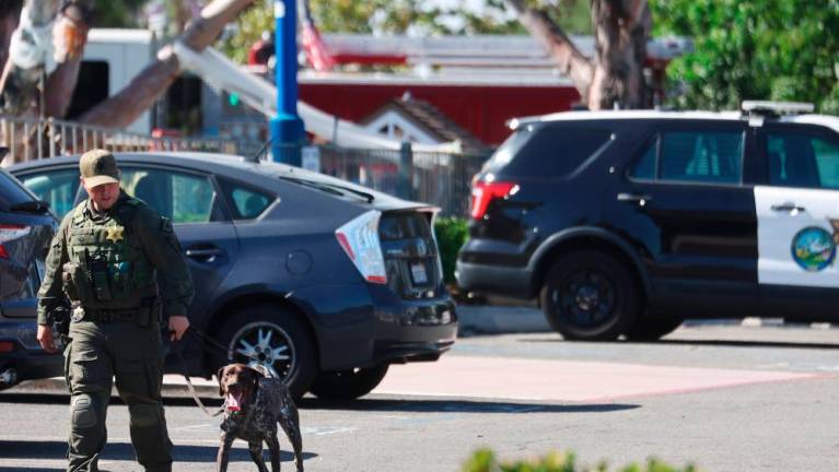 A police officer leads a canine at the scene of a shooting at the Geneva Presbyterian Church on May 15, 2022 in Laguna Woods, California. AFPPIX