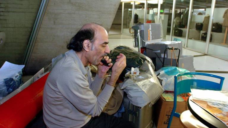 (FILES) In this file photo taken on August 12, 2004 Mehran Karimi Nasseri shaves, early in the morning, in the terminal 1 of Paris Charles De Gaulle airport. - AFPPIX