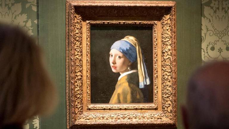 Visitors looks at the Johannes Vermeer's painting Girl with a Pearl Earring at the Mauritshuis museum in The Hague, 27 October 2022. - AFPPIX