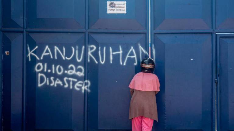 TOPSHOT - A woman visits Kanjuruhan stadium, the site of a deadly stampede, in Malang, East Java on October 4, 2022.- AFPPIX