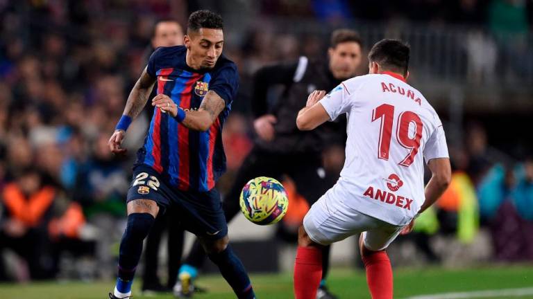 Barcelona’s Brazilian forward Raphinha (L) fights for the ball with Sevilla’s Argentinian defender Marcos Acuna during the Spanish league football match between FC Barcelona and Sevilla FC at the Camp Nou stadium in Barcelona, on February 5, 2023/AFPPix