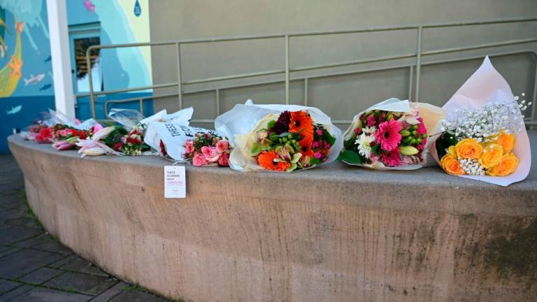 A row of bouquets placed across the street from the Half Moon Bay city hall in honor of the shooting victims in Half Moon Bay, California, on January 24, 2023/AFPPix