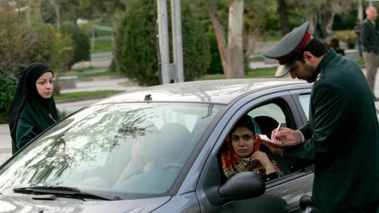 (FILES) In this file photo taken on April 22, 2007, Iranian police officers stop a car during a crackdown to enforce the Islamic dress code in the north of the capital Tehran. - AFPPIX