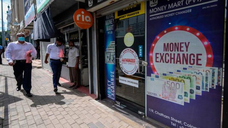 Pedestrians passing a currency exchange shop in Colombo on Monday, March 20, 2023. Cash-strapped Sri Lanka is seeking a 10-year moratorium on its foreign debt – AFPpic