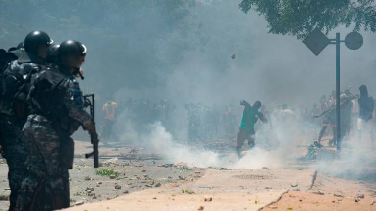 Supporters of opposition leader, Ousmane Sonko throw stones while police fire tear gas in Dakar on June 1, 2023, during unrest following the sentence of opponent Ousmane Sonko. AFPPIX