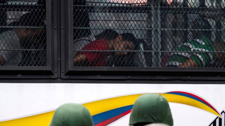 Members of the Bolivarian National Guard (GNB) stand guard as inmates aboard a bus are transferred outside the Tocoron prison in Tocoron, Aragua State, Venezuela, on September 20, 2023. AFPPIX