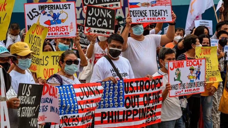 Protesters hold anti-US placards during a rally in front of the military headquarters in Quezon City, suburban Manila on February 2, 2023, as US Secretary of Defense Llyod Austin and his Philippine counterpart Carlito Galves held a bilateral meeting. AFPPIX