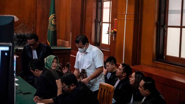 Police officer Hasdarmawan (C) talks to his lawyers during his trial at a courthouse in Surabaya on March 16, 2023. AFPPIX