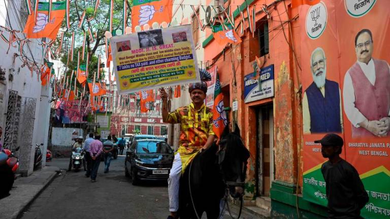 A Bharatiya Janata Party (BJP) activist holds a placard in support of India’s Prime Minister Narendra Modi and the union budget while riding a horse in Kolkata on February 7, 2023. AFPPIX