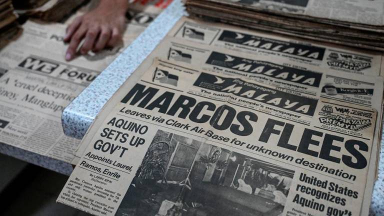 This photo taken on September 3, 2022 shows copies of the Philippine newspaper Ang Pahayagang Malaya dated February 26, 1986 with the headline of then-dictator Ferdinand Marcos Sr. fleeing the country, among other period publications to be archived, in Taguig, suburban Manila. - AFPPIX