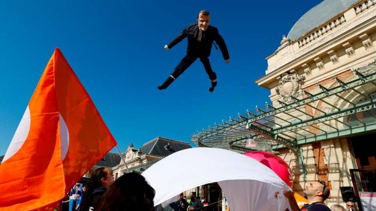 A puppet depicting French President Emmanuel Macron is tossed into the air by French workers on strike during a demonstration on the eve of the ninth day of national strike and protests, and after the pension reform was adopted as the French Parliament rejected two motions of no-confidence against the government, in Nice, France, March 22, 2023. REUTERSPIX
