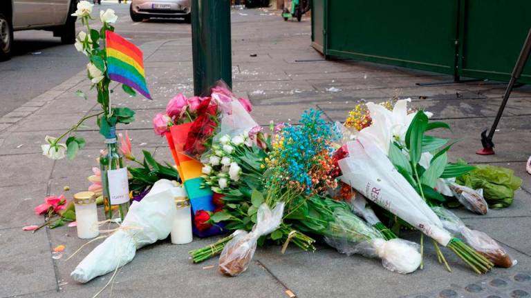 Flowers and a rainbow flag are placed on the sidewalk as a tribute to the victims of a shooting at the London Pub, a popular gay bar and nightclub, in central Oslo, Norway June 25, 2022. REUTERSPIX