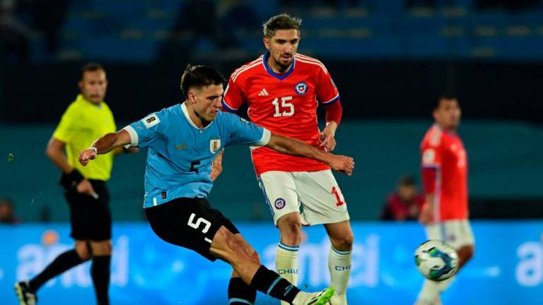Uruguay's midfielder Manuel Ugarte (L) strikes the ball past Chile's midfielder Diego Valdes during the 2026 FIFA World Cup South American qualifiers football match between Uruguay and Chile, at the Centenario stadium in Montevideo, on September 8, 2023. AFPPIX