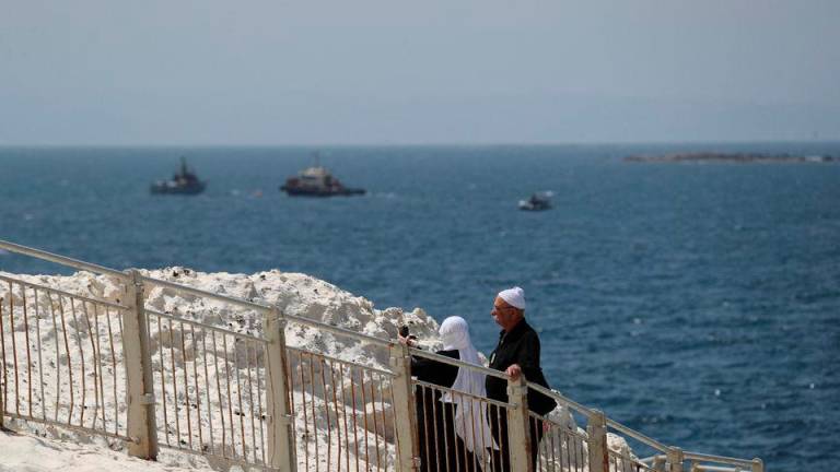 People walk as Israeli navy boats are seen in the Mediterranean Sea as seen from Rosh Hanikra, close to the Lebanese border, northern Israel May 4, 2021. REUTERSPIX