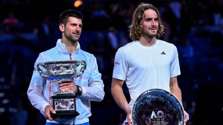 Serbia’s Novak Djokovic (L) holding the Norman Brookes Challenge Cup poses with Greece’s Stefanos Tsitsipas (R) afer his victory during the men’s singles final on day fourteen of the Australian Open tennis tournament in Melbourne on January 29, 2023. AFPPIX