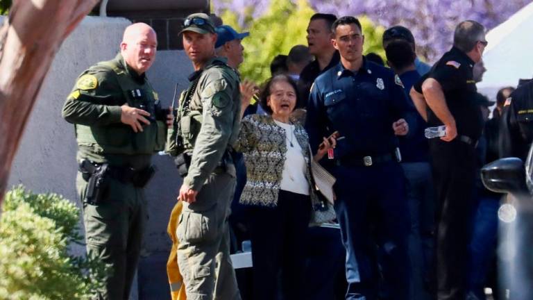 Seorang wanita bertindak balas di sebelah pegawai penguat kuasa selepas tembakan maut meletus di Gereja Presbyterian Geneva di Laguna Woods, California, A.S. 15 Mei 2022. REUTERSPIX